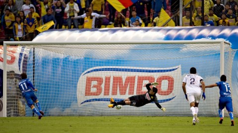 El portero del América, Moisés Muñoz (centro), se lanza sin éxito para atajar un penal de Ezequiel Cuevas (11).