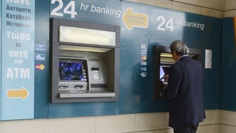 Un hombre retira dinero del cajero de la sucursal de un banco en Nicosia (Chipre).
