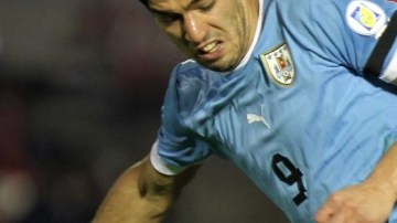 El jugador paraguayo Cristian Riveros (atrás) marca al uruguayo Luis Suárez, durante el partido en el Estadio Nacional de Montevideo.