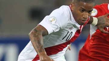 Eugenio Mena (der.) disputa la pelota con el peruano Jefferson Farfán.
