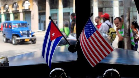 Banderas de EEUU y Cuba en miniatura adornan un auto en la isla.