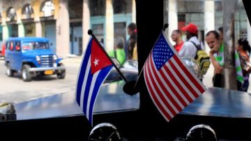 Banderas de EEUU y Cuba en miniatura adornan un auto en la isla.