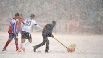 La nevada fue tan intensa que hasta los jugadores ayudaron a los trabajadores a limpiar el terreno de juego.