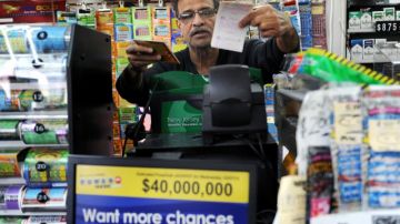 Baiju Amin le  vende un boleto de  lotería a un cliente en Totowa,  NJ.