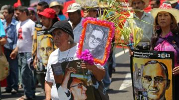 Salvadoreños llevaban pósters del asesinado  arzobispo Oscar Romero durante una procesión del Domingo de Ramos ayer, en San Salvador.