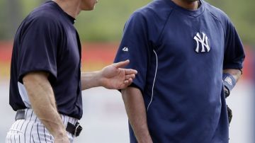 El manager de los Yankees, Joe Girardi (izq.), dialoga con el capitán Derek Jeter durante un juego de la pretemporada en el Complejo de Tampa, en Florida.