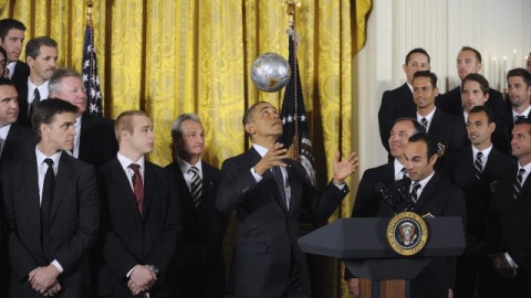Barack Obama domina el balón con la cabeza al recibir a jugadores del Galaxy (der.) y de los Kings (izq.).