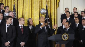 Barack Obama domina el balón con la cabeza al recibir a jugadores del Galaxy (der.) y de los Kings (izq.).