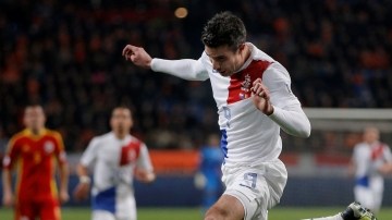 El holandés  Robin van Persie cabecea el balón, mientras lo espera el  arquero de Rumania, Costel Fane.