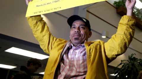 Pedro Quezada,  ganador del  Powerball, sostiene el cheque promocional por la cantidad de $338 millones, en New Jersey.