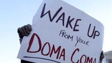 Una partidaria de los matrimonios de personas del mismo sexo, Carolyn Marosy, sostiene un cartel en el que se lee "¡Despertad de vuestro DOMA coma!"), " ante el Tribunal Supremo de Estados Unidos en Washington DC.