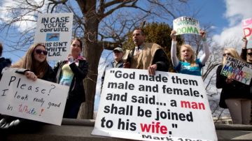 Allan Hoyle of North Carolina, with the large white sign, center, speaks out against gay marriage across from the street from the Supreme Court in Washington, Wednesday, March 27, 2013, after the court heard arguments on the Defense of Marriage Act (DOMA) case. The U.S. Supreme Court, in the second day of gay marriage cases, turned Wednesday to a constitutional challenge to the federal law that prevents legally married gay Americans from collecting federal benefits generally available to straight married couples. (AP Photo/Carolyn Kaster)