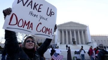 Una partidaria de los matrimonios de personas del mismo sexo, Carolyn Marosy, sostiene un cartel en el que se lee "¡Despertad de vuestro DOMA coma!"ante el Tribunal Supremo de Estados Unidos en Washington DC.