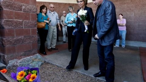 La excongresista Gabrielle Giffords (c), con su esposo, Mark Kelly, visitan el lugar donde ocurrió el ataque.