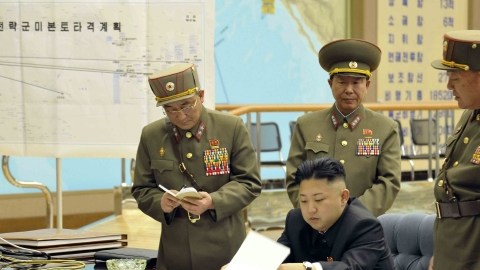 El líder norcoreano, Kim Jong-un (c), durante una reunión en la madrugada de este viernes en un lugar indeterminado, en la que ordenó tener preparados sus misiles para atacar en "cualquier momento" intereses de EEUU y Corea del Sur.