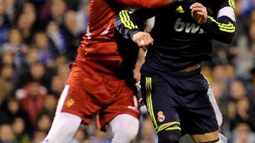 Sergio Ramos, del Real Madrid, choca con el arquero Roberto Jiménez, en una acción del encuentro disputado en La Rosaleda.