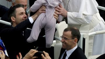 El Papa Francisco besa a un bebé después de celebrar la Misa de Resurección en la Plaza de San Pedro en el Vaticano.