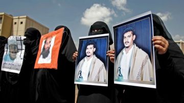 Mujeres de Yemen sostienen fotos de sus familiares detenidos en Guantánamo durante una protesta en frente de la embajada de EE.UU. en Sanaa, Yemen.