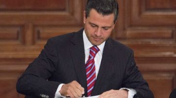 El presidente de México, Enrique Peña Nieto, mientras suscribía ayer  una nueva Ley de Amparo, en el Palacio Nacional.