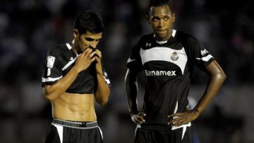 Francisco Gamboa (i), y Matías Wilson, de Toluca,  al final del partido de la Copa Libertadores de fútbol contra el Nacional de Uruguay en Montevideo, Uruguay, en el que Nacional ganó 4-0.