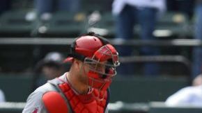 El receptor de Angels Chris Iannetta (i) pierde el control de la pelota en la octava entrada, y permite la carrera de la victoria de los Rangers de Texas a Graig Gentry (d).