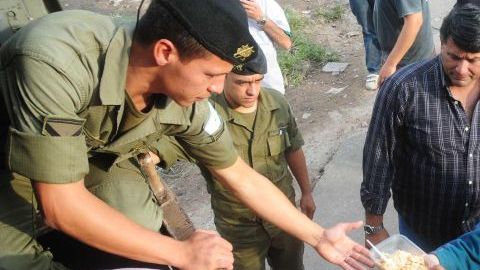 Miembros del Ejército argentino entregan alimentos y colchones a filas de damnificados en La Plata (Argentina).