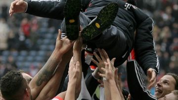 Los jugadores del FC Bayern Munich levantan a su técnico, Jupp Heynckes, que se retirará al final de la temporada, tras conquistar el campeonato de la Bundesliga.