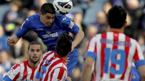El  marroquí del Getafe Abdel Barrada (c) trata de anotar  ante varios    jugadores del Atlético Madrid.
