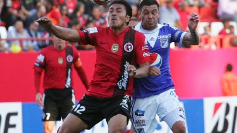 El jugador del Xolos, Noé Maya (izq.), disputa el balón con José Tancredi, del Millonarios, en la cancha del Estadio Caliente.