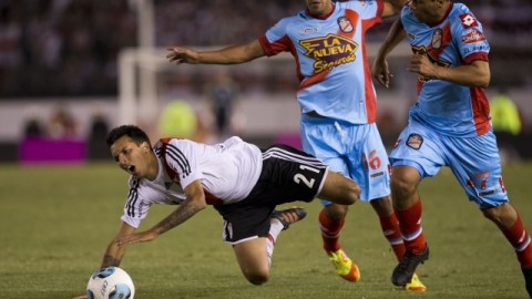 Leonel Vangioni, del River Plate, es deribado por Gonzalo Espinoza (centro) y Eduardo Casais, del Arsenal, en el encuentro de ayer en El Monumental, de donde los aficionados se fueron decepcionados.