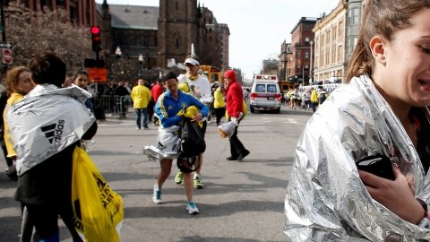Una corredora del Maratón de Boston, no identificada, sale llorando de la ruta de la carrera cerca de  Copley Square tras un par de explosiones casi al llegar a  la  meta.