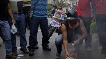 Seguidores de Maduro prendieron fuego hoy a afiches del opositor Capriles.