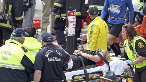 Rescatistas atienden a un herido después de la explosión ayer en el maratón de Boston.