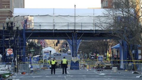 Dos policías hacen guardia junto a la meta de la maratón de Boston, mientras continúan las investigaciones en el escenario de las dos explosiones que causaron ayer la muerte a tres personas en Boston, Massachusetts.