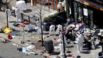 Investigadores en la escena de la explosión recolectan datos y pistas ayer en el lugar donde detonaron dos bombas durante la carrera de Boston.