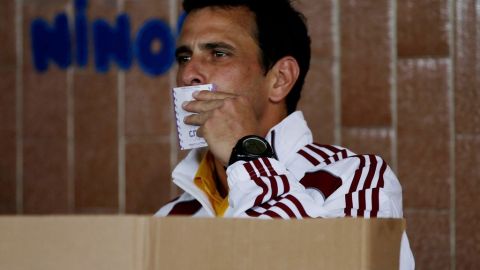 El candidato opositor Henrique Capriles al momento de depositar su voto en una urna.