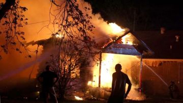 Bombertos combaten el incendio de una vivienda en West, Texas, ocurrido durante la explosión e incendio de una fábrica de fertilizantes cercana.