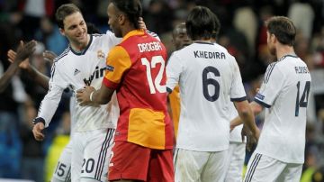 El marfileño Didier Drogba (12), del Galatasaray, felicita al argentino Gonzalo Higuaín (20) del Real Madrid, en el cotejo que los merengues clasificaron a las semifinales de la Champions. También aparece el alemán Khedira (6).