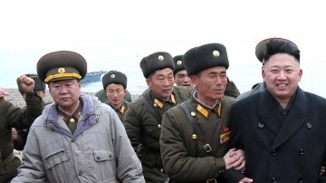 El líder norcoreano Kim Jong Un, centro, camina con una unidad militar tras su arribo a Mu Islet, localizado en el suroeste de la frontera con Corea del Sur.