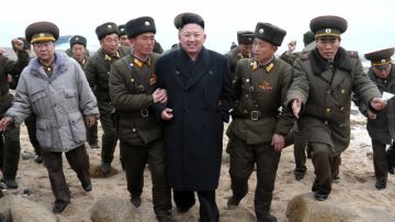 El líder norcoreano Kim Jong Un, centro, camina con una unidad militar tras su arribo a Mu Islet, localizado en el suroeste de la frontera con Corea del Sur.