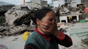 El pueblo de  Lushan Ya'an, al suroeste de China's fue uno de los lugares más devastados por el sismo que se produjo ayer. Una residente busca consuelo en medio de las ruinas.