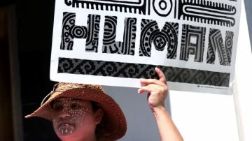 Una activista muestra un letrero pro-inmigrante tras conocer la iniciativa del Grupo de los Ocho.