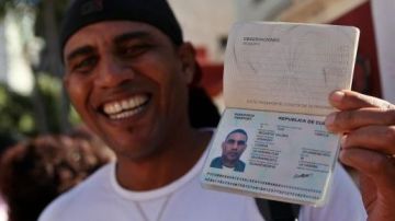 Un hombre muestra su pasaporte al salir de la oficina de Inmigración y Extranjería en La Habana.