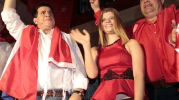 El presidente paraguayo electo, Horacio Cartes (i), saluda a seguidores junto a su vicepresidente, Juan Afara (d), y acompañado de su hija Sol (c)  frente a la sede del local partidario de la Asociación Nacional Republicana de Asunción (Paraguay).