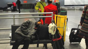 Un pasajero se queda dormido tras una larga espera en el Aeropuerto LaGuardia en Queens.