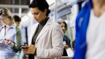 Una mujer envía un mensaje de texto en un  vagón de los trenes de Nueva York.