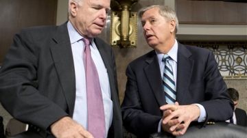 Los senadores republicanos John McCain (iqda) y Lindsey Graham conversan en el Senado.
