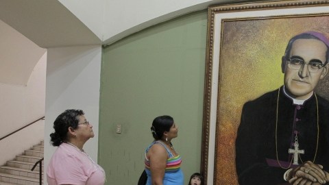 Salvadoreñas observan pintura del arzobispo asesinado de San Salvador Óscar Arnulfo Romero.
