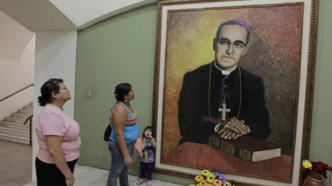Salvadoreñas observan pintura del arzobispo asesinado de San Salvador Óscar Arnulfo Romero.