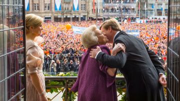 Beatriz (c) felicita a su hijo Willem-Alexander y a su esposa Máxima (i) mientras el pueblo observa al fondo.